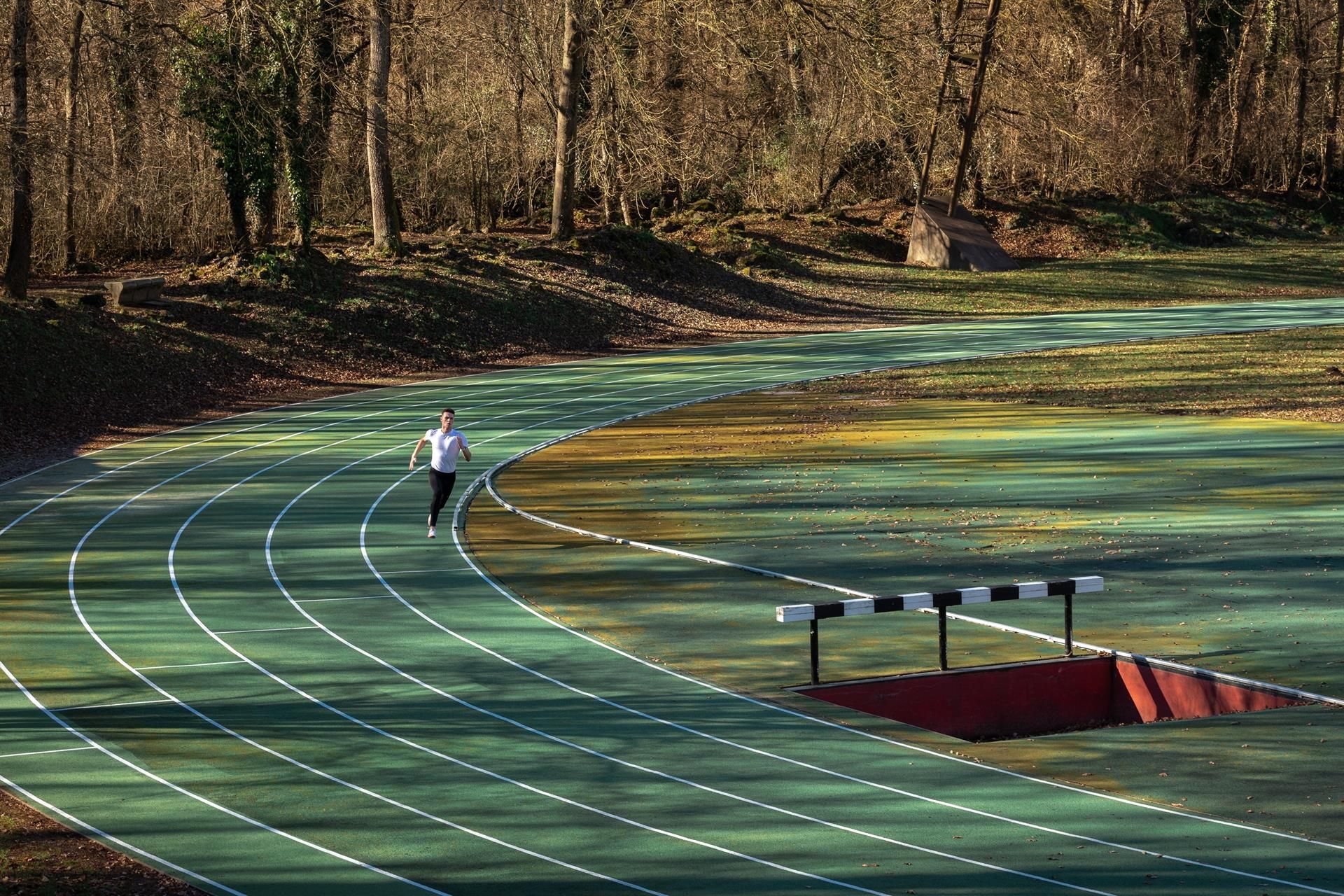 En medio del bosque surge la pista de atletismo de Olot. Un rincón único en el que correr. EFE.