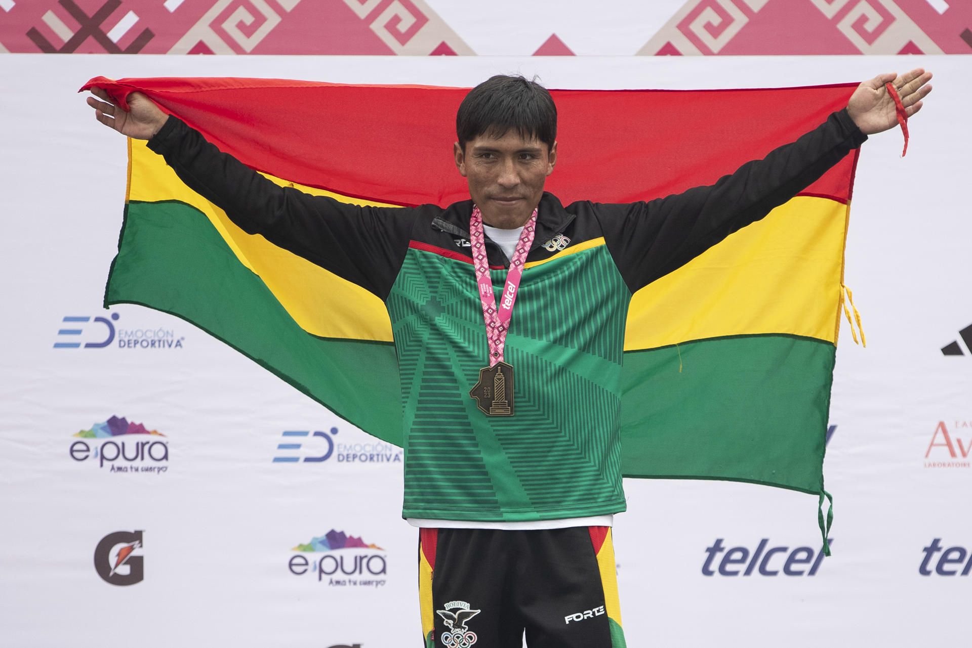 El atleta boliviano Héctor Garibay posa hoy con su medalla y la bandera de su país tras ganar el primer lugar de la rama varonil del XL Maratón de la Ciudad de México (México). EFE.