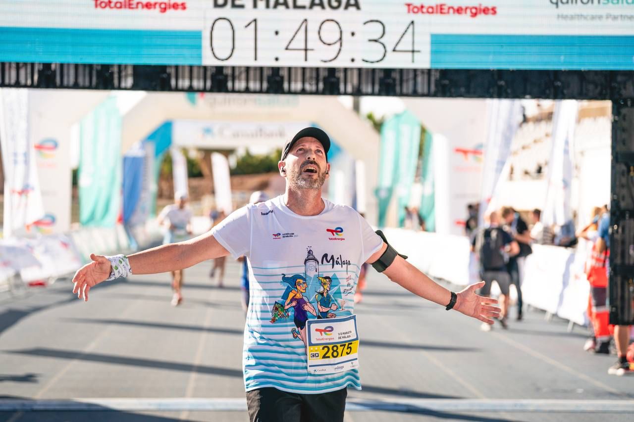 Un participante en la línea de meta del Total Energies Medio Maratón de Málaga Un participante en la línea de meta del Total Energies Medio Maratón de Málaga