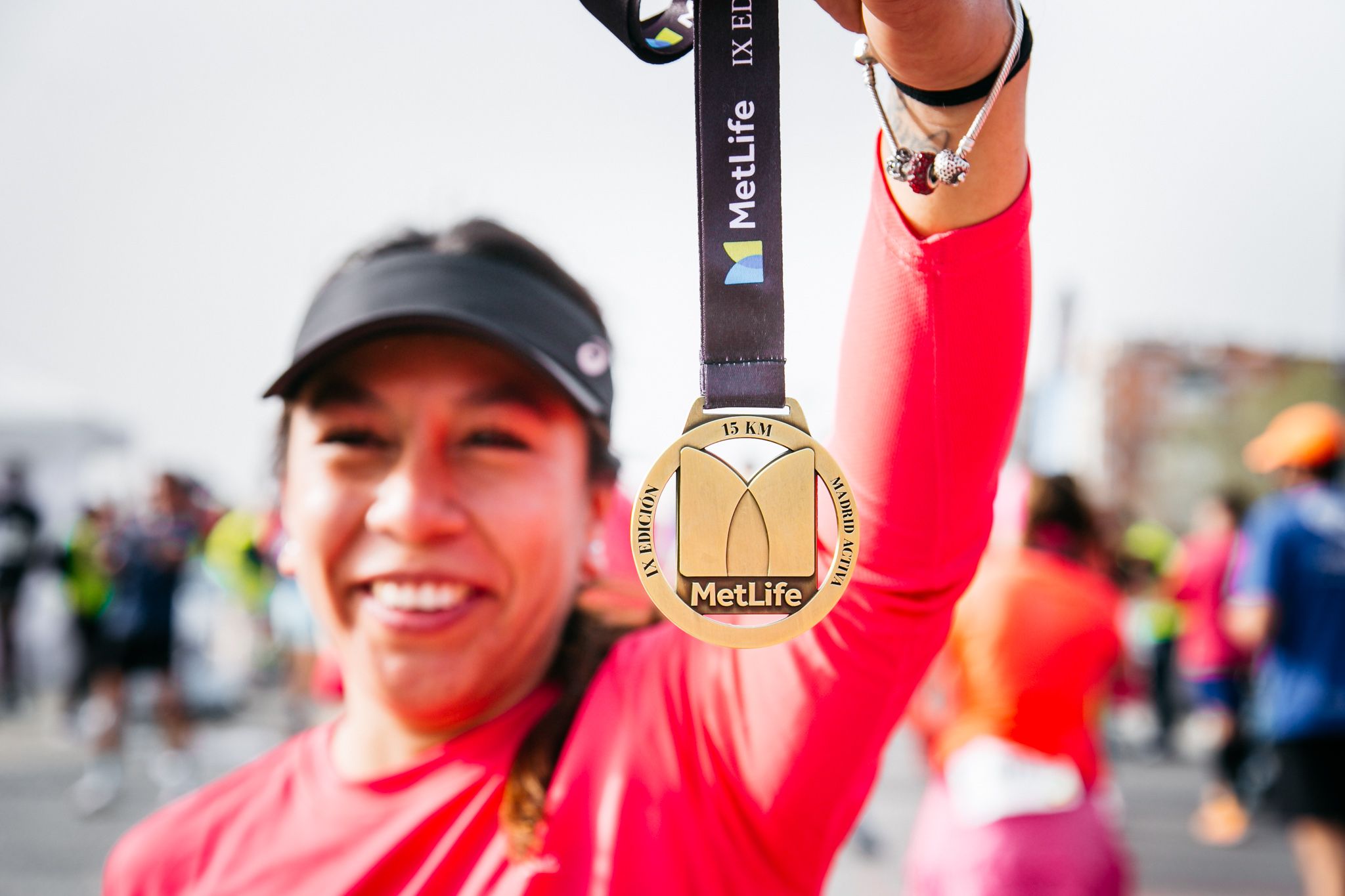 Una participante en la línea de meta de la última edición de la 15K Metlife Madrid con la medalla de finisher
