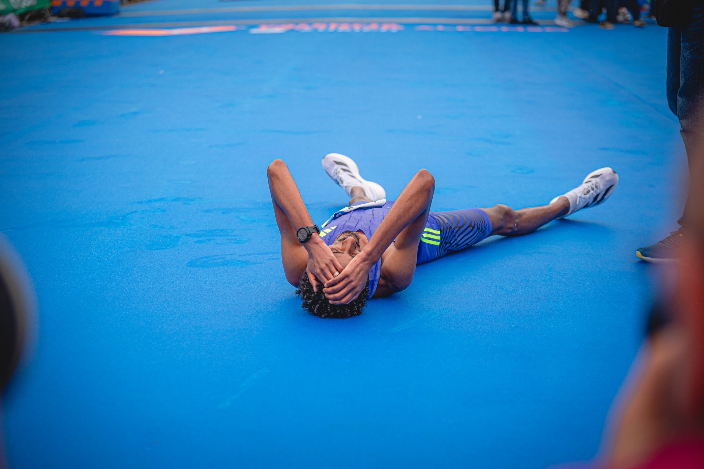 Kejelcha, en el suelo, celebra el récord del mundo de medio maratón. VSM PHOTOEVENTS.