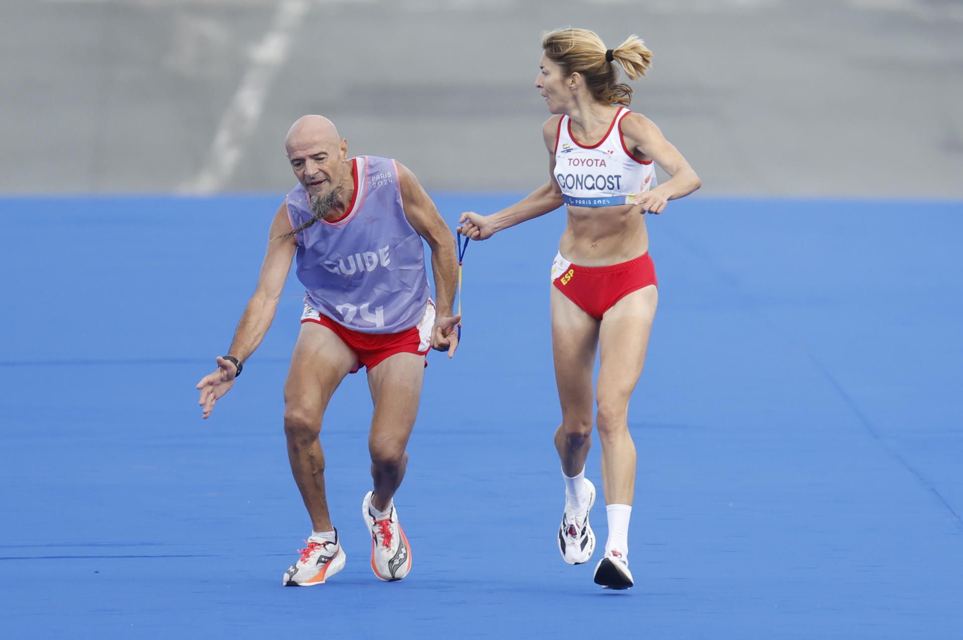 La atleta española Elena Congost, competidora de la maratón T12 femenino, ayuda a su guía, que llega exhausto a la línea de meta, en los Juegos Paralímpicos de París 2024, en una foto de archivo. EFE.