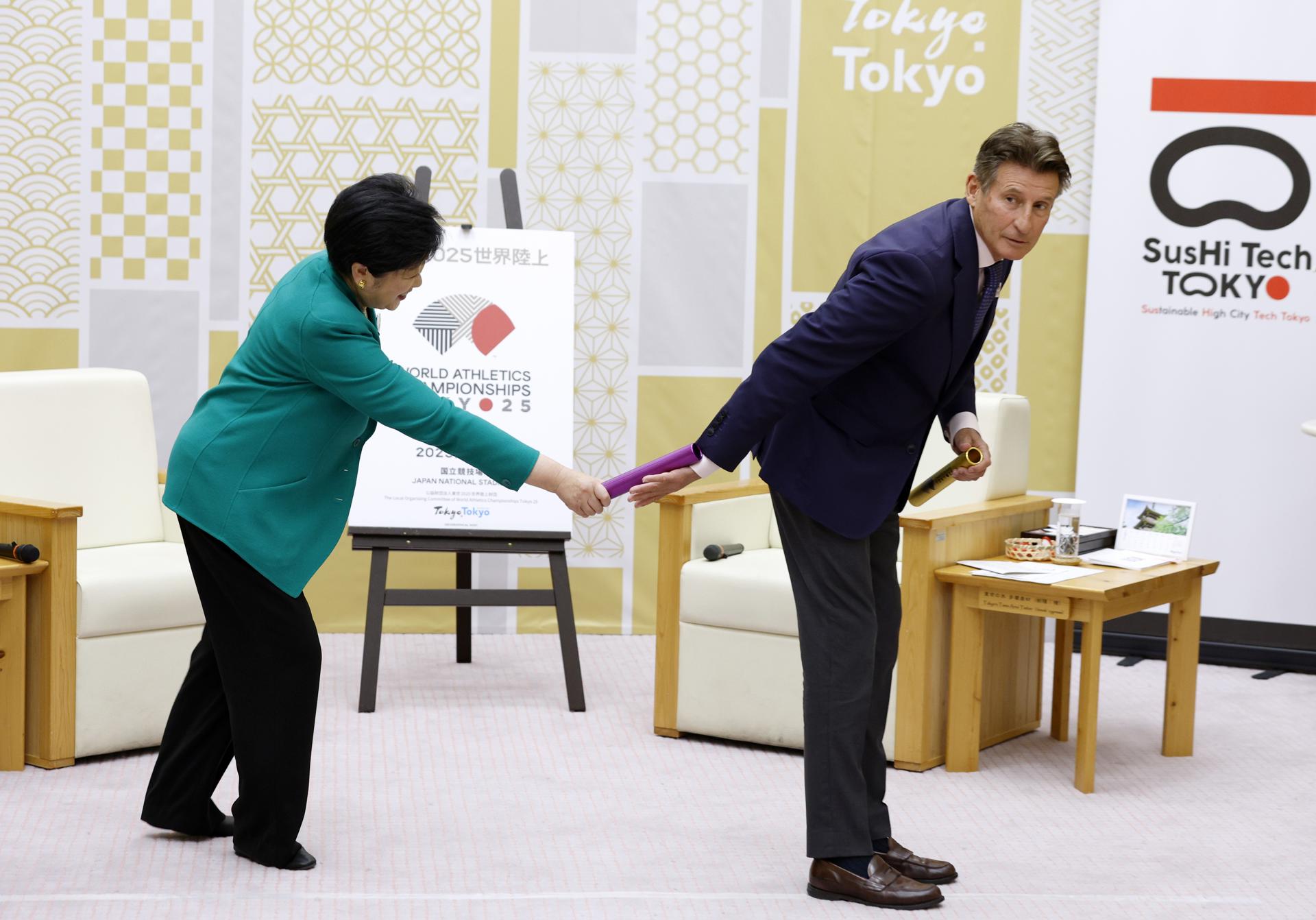 El presidente de la World Athletics, Sebastian Coe, recibe un relevo de la Gobernadora de Tokio, Yuriko Koike, durante la reunion que mantuvieron hoy. EFE.