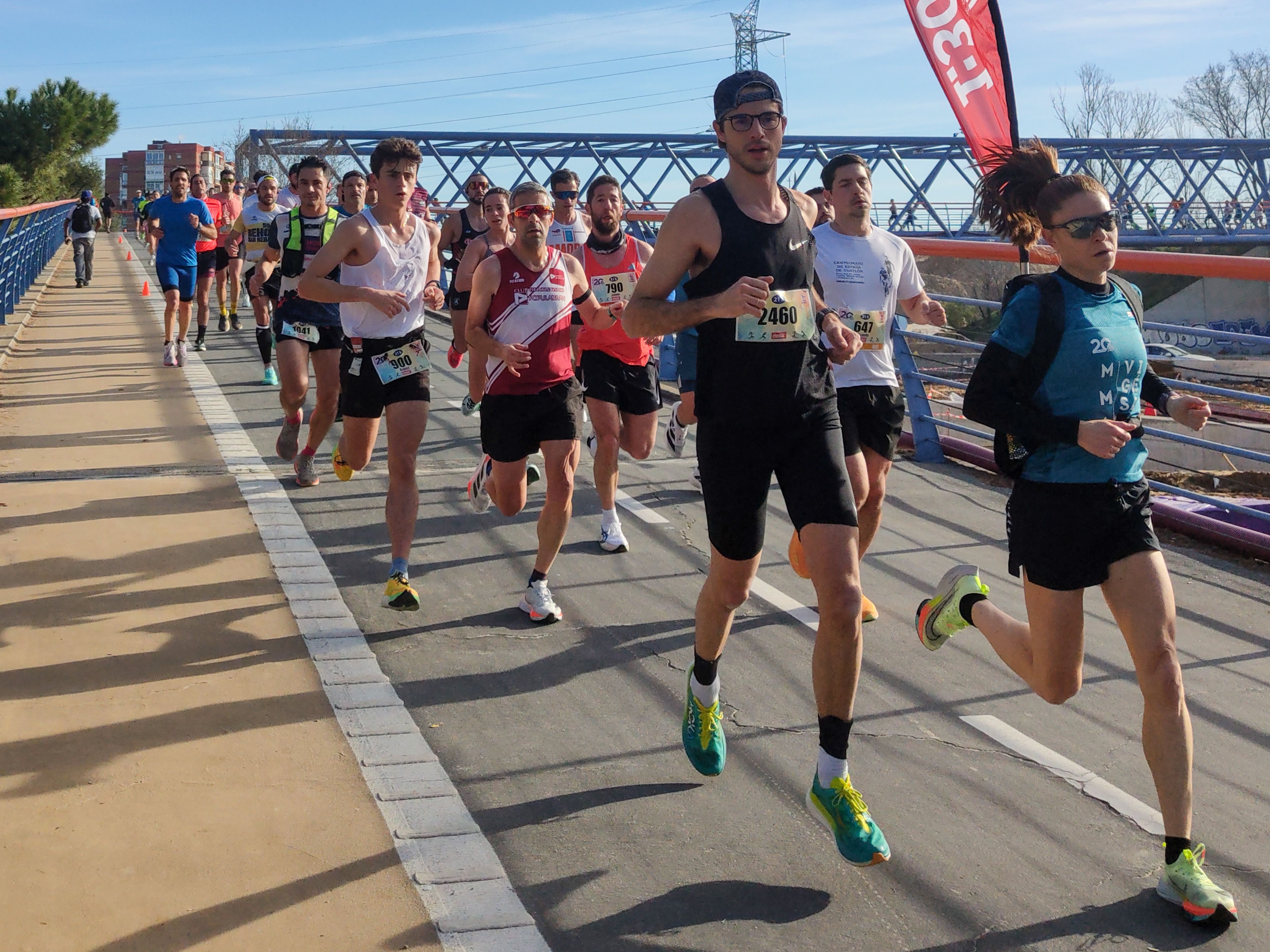 Los corredores a su paso por la pasarela que conecta Aluche y la Casa de Campo.