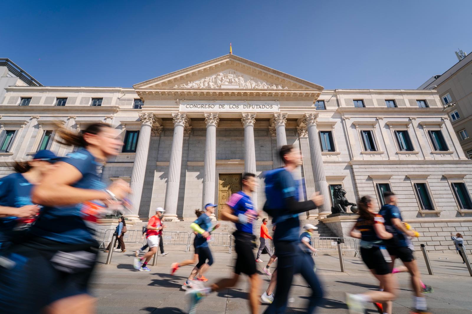 Los corredores del Movistar Madrid Medio Maratón al paso por el Congreso de los Diputados