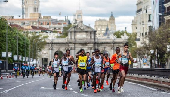 Corredores de la Movistar Media de Madrid a su paso por la Puerta de Alcalá